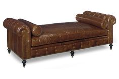 a brown leather chaise lounger on casteors