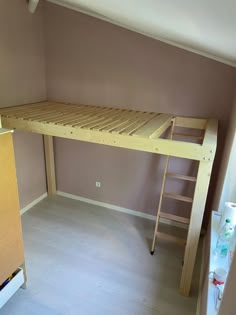 a bunk bed sitting in the corner of a room next to a ladder and wall