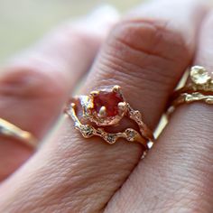 a close up of a person's hand with two rings on their fingers and one is wearing an engagement ring