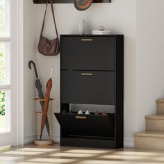 a black cabinet sitting in the corner of a room with umbrellas and other items