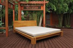 a bed sitting on top of a wooden floor next to a pergolated area