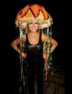 a woman in black shirt standing next to a large colorful headdress on her head