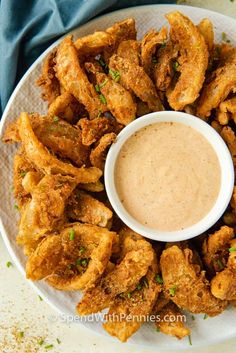 a white plate topped with fried chicken wings and dipping sauce