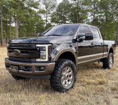 a black truck parked in the middle of a field