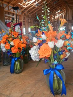 three vases filled with flowers on top of a wooden table next to each other