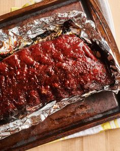 the meat is covered in tin foil and ready to be cooked on the grilling pan