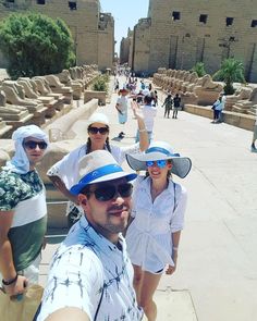 some people are taking a selfie in front of the ruins