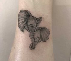 an elephant and its baby tattoo on the left ankle, which is drawn in black ink