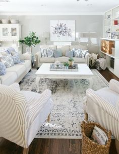 a living room filled with white furniture and lots of pillows on top of it's couches