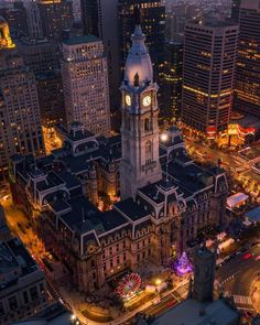 an aerial view of a city at night with tall buildings and a clock tower in the center