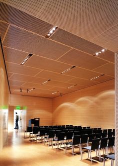 an empty room with rows of black chairs