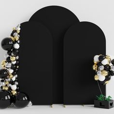 a black and gold balloon arch with some balloons attached to the wall next to it