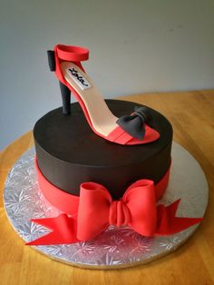 there is a cake that has a shoe on it and a bow around the top