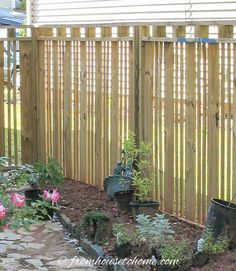 an outdoor garden with flowers and plants in the ground, next to a wooden fence that says diy custom fence design