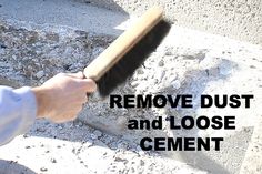 a person using a brush to remove dust and loose cement