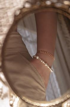 a close up of a person's hand with a bracelet on their wrist in front of a mirror