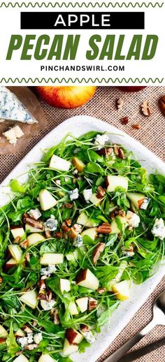 an apple and pecan salad is served in a white platter with silverware