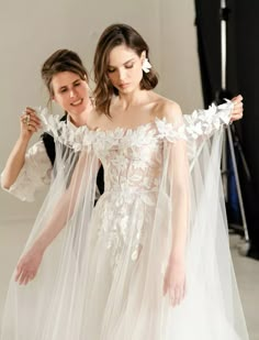 two women in wedding dresses with veils