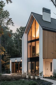 a modern house in the woods with large windows