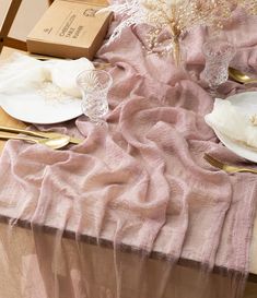 the table is set with pink linens and gold place settings, including silverware