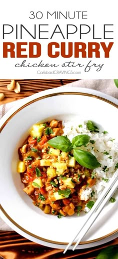 a white plate topped with rice and pineapple red curry next to chopsticks