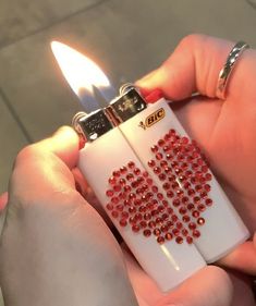 a person holding a lighter with red crystals on it