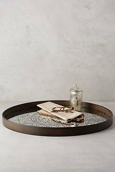 a tray with some food on it and a glass bottle next to it in front of a white wall