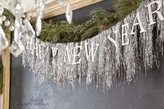 a sign that says happy new year hanging from the side of a chalkboard wall