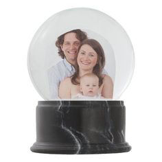 a snow globe with an image of a man and woman holding a baby