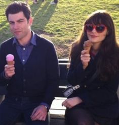 two people sitting on a bench eating ice cream