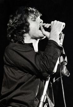 a man singing into a microphone on stage