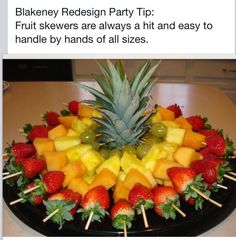 a fruit platter with strawberries, pineapples and grapes