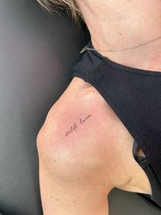 a woman with a tattoo on her left shoulder and the word love written in cursive writing