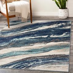 a blue and white area rug in a living room with a chair next to it