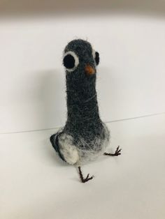 a small bird made out of felt sitting on top of a table