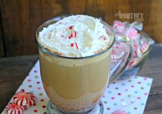 a glass mug filled with whipped cream and candy canes