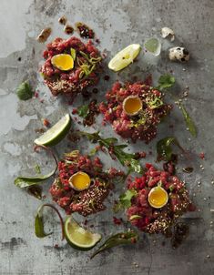 some food is laying on a table with lemons and other things around it, including an egg