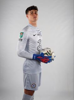 a young man holding a soccer ball and glove