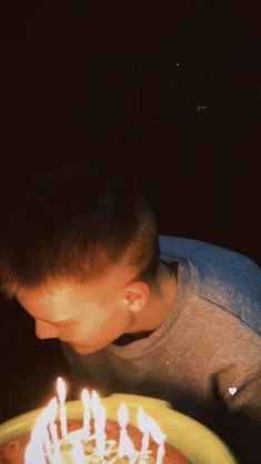 a young boy blowing out candles on a cake