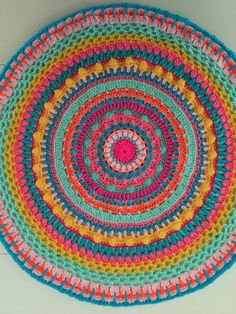 a multicolored crocheted round rug on the floor