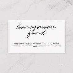 a white business card with the words honeymoon fund written in cursive writing on it