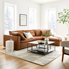 a living room filled with furniture and a coffee table on top of a wooden floor