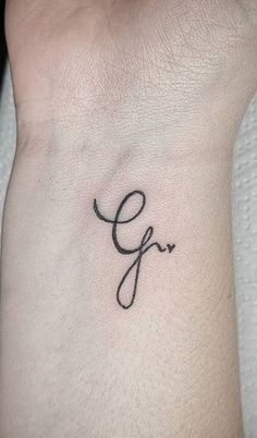 a small wrist tattoo with the letter f on it