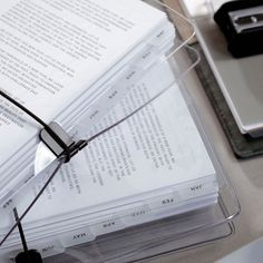 a stack of books sitting on top of a table next to a laptop computer and glasses