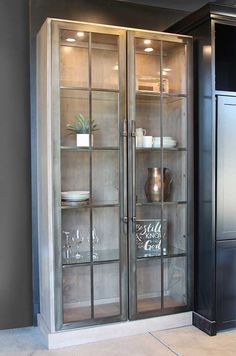 an empty glass cabinet in the corner of a room