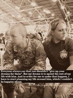 a man and woman sitting next to each other in front of a building with a quote on it