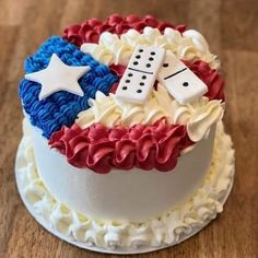 a cake with red, white and blue icing on it sitting on top of a wooden table