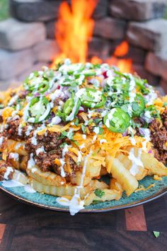 a plate full of food sitting on top of a table next to a fire pit