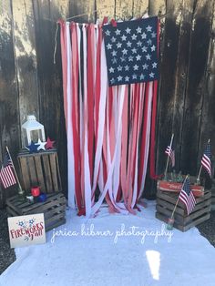 an american flag backdrop with red, white and blue streamers in front of it