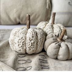 three white pumpkins sitting on top of a pillow